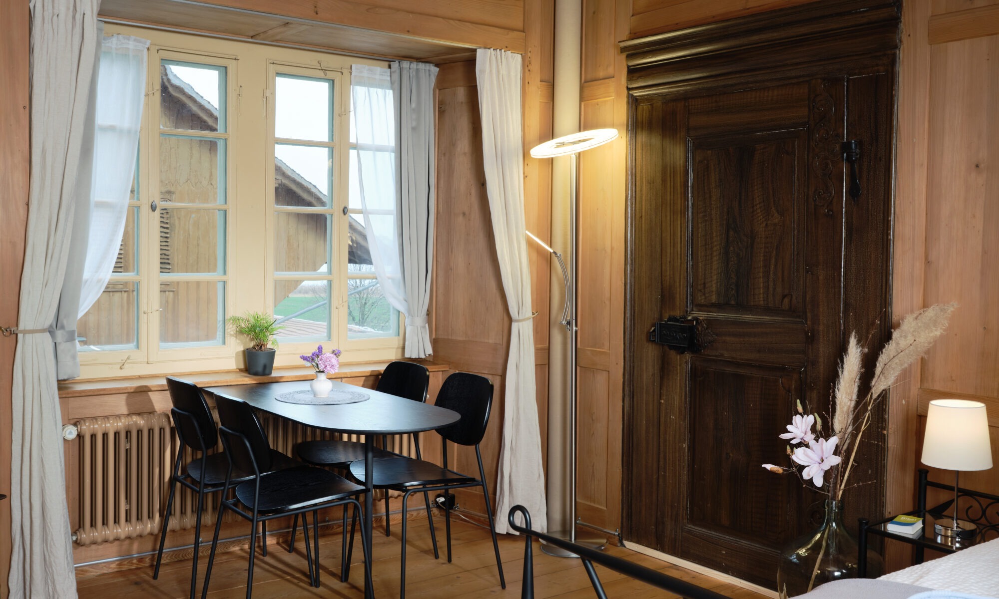 Esstisch mit vier Stühlen vor einem Fenster