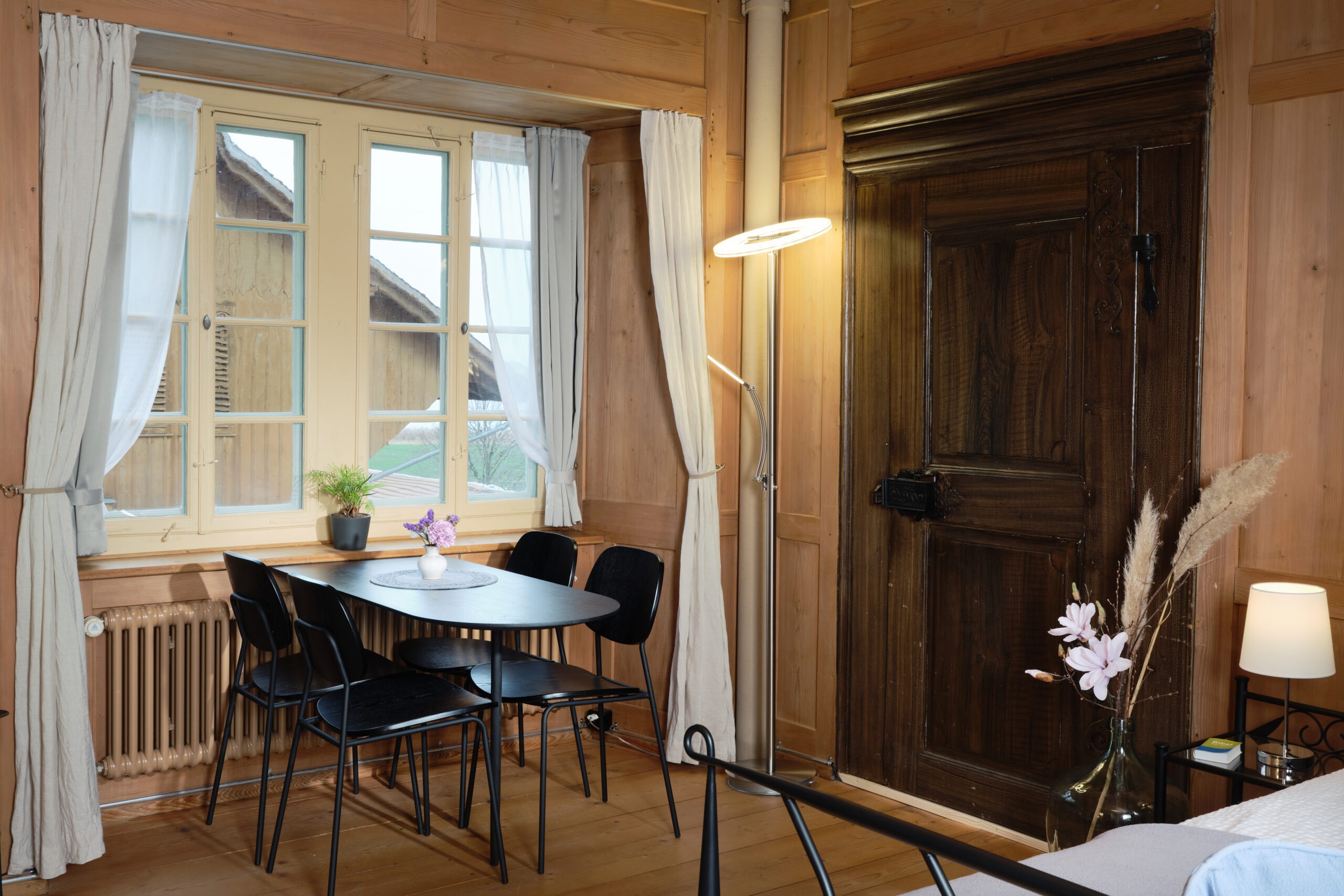 Esstisch mit vier Stühlen vor einem Fenster